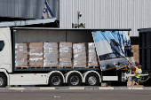 A worker displays the supplies in a truck carrying aid at the Kerem Shalom crossing between Israel and Gaza, on the Israeli side of the Israel-Gaza border