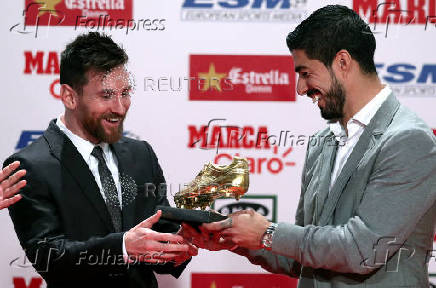 FILE PHOTO: Barcelona's Lionel Messi receives his fourth Golden Boot trophy from Luis Suarez during a ceremony in Barcelona