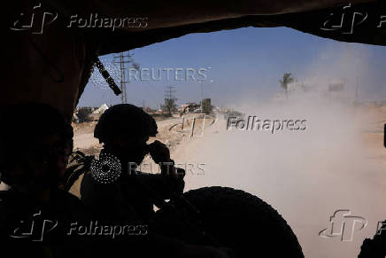 An Israeli soldier sits in a military vehicle as part of a convoy in a street in the Gaza Strip amid the ongoing ground operation of the Israeli army against Palestinian Islamist group Hamas