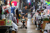 A man pushes a baby cart inside a market, in Dong Dang township