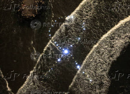 A drone view shows Israeli protesters display lights in the waters of the Mediterranean, in the shape of a ribbon symbolising support for hostages kidnapped from Israel by Hamas, in Tel Aviv