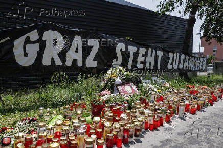 Flowers and candles are seen in front of the fences of the school in Graz