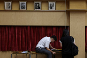 A secondary school student sits after receiving his Diploma of Secondary Education (DSE) exam results in Hong Kong