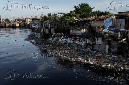 Children pick through washed-up garbage along the polluted Pasig River on World Environment Day in Manila