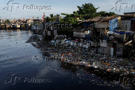 A drone view shows children picking through washed-up garbage along the polluted Pasig River on World Environment Day in Manila