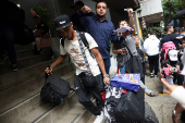 Migrants gather outside the Venezuelan embasssy waiting for a flight back to their country