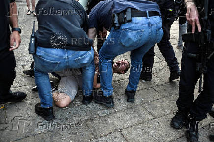 Israeli policemen detain a protestor during a protest against the war in Gaza at Haifa