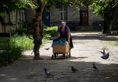 A resident pulls a cart near a Ukrainian serviceman in the frontline town of Kostyantynivka