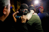 Arturo Suarez, who was held for months in an El Salvador prison, greets family members after his release, in Caracas