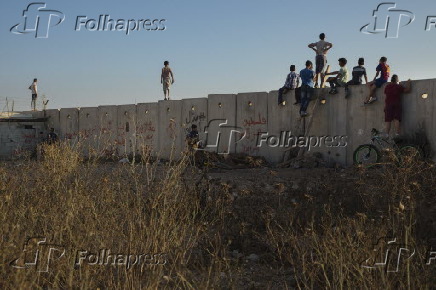 Crianças palestinas observam soldados israelenses em Ramalá