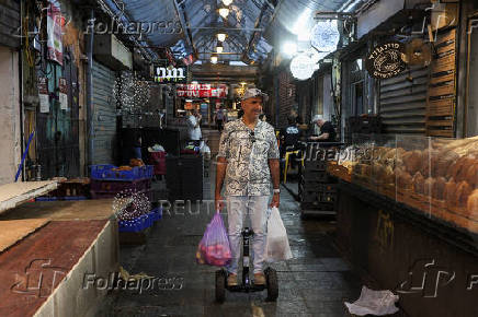 People shop in Jerusalem following an Israeli strike in Iran