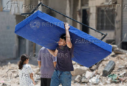 Palestinians carry their belongings after Israel's decision to demolish their homes in Nur Shams camp