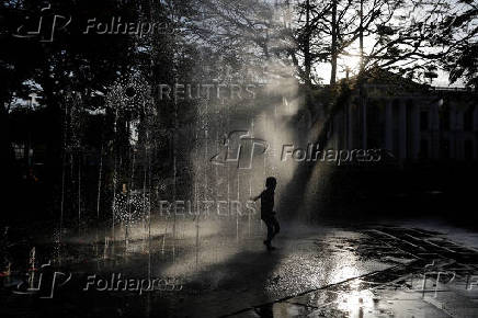 Children play at a fountain in San Salvador