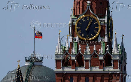 FILE PHOTO: The Russian flag flies on the dome of the Kremlin Senate building behind Spasskaya Tower in Moscow