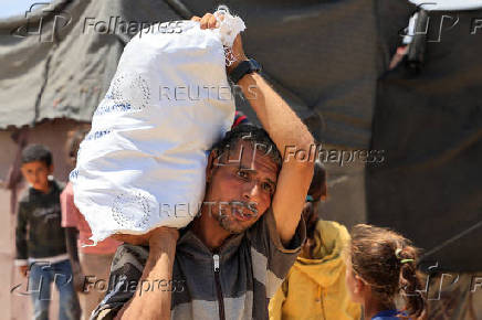 Palestinians carry aid supplies they received from the U.S.-backed Gaza Humanitarian Foundation, in Khan Younis