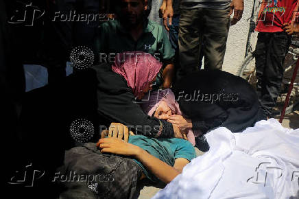Palestinians gather around casualties of Israeli fire, who were seeking aid in northern Gaza, according to medics, in Gaza City