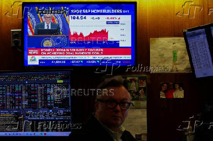 Traders work, as a screen broadcasts a press conference by U.S. Federal Reserve Chair Jerome Powell following the Fed rate announcement, on the floor of the NYSE in New York