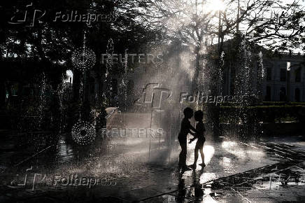 Children play at a fountain in San Salvador