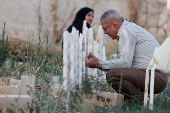 Palestinians visit graves of their relatives at a cemetery in Jenin camp