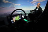 A member of BAE Systems staff demonstrates a new and improved cockpit display for the companies Typhoon military jets in an aircraft simulator at  their Warton factory in Warton