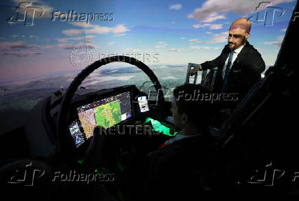A member of BAE Systems staff demonstrates a new and improved cockpit display for the companies Typhoon military jets in an aircraft simulator at  their Warton factory in Warton