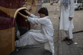 Man replaces tire on a bus in Rawalpindi, Pakistan