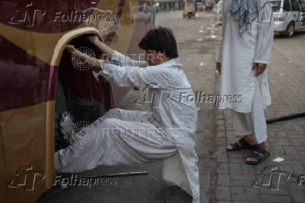 Man replaces tire on a bus in Rawalpindi, Pakistan