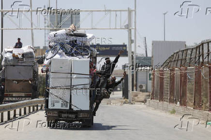 A truck transporting families, loaded with their belongings, drive through Bab al-Salameh border crossing, in Aleppo's countryside