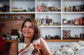 Daniela Falcão posa com obra em casa durante entrevista