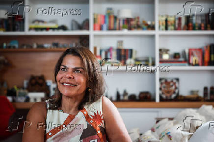 Daniela Falcão posa com obra em casa durante entrevista