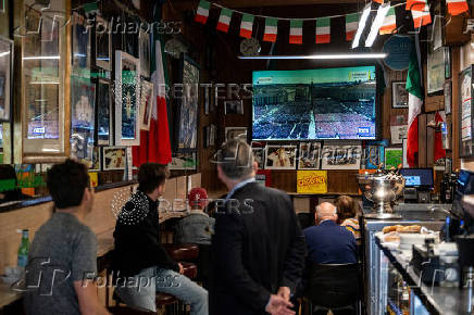 People watch the Pope's funeral in London