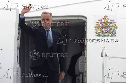 FILE PHOTO: Canada's Prime Minister Mark Carney waves as he boards his plane for Washington, D.C., in Ottawa