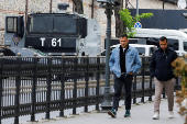 Men walk near a security vehicle outside the Turkish Presidency's Dolmabahce working office, in Istanbul