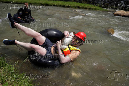 Sports enthusiasts compete while floating on inner tyre tubes during the tyre festival 'Bunar Fest' in Prizren