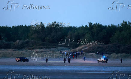 Police disperse a group of migrants trying to cross the beach to reach a dinghy whilst trying to cross the English Channel on a beach at Gravelines