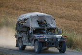 An Israeli military vehicle patrols by the Israel-Gaza border