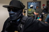 A migrant is detained by federal immigration officers at U.S. immigration court