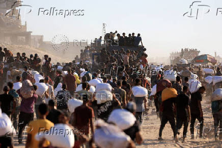 Palestinians carry aid supplies that entered Gaza through Israel, in Beit Lahia