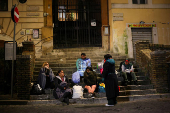 People rest while waiting to pay respects as Pope Francis lies in state, in Rome