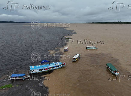A drone view shows boats navigating over the confluence between Rio Negro and the Solimoes river during a symbolic act of the Pilgrimage of the Waters near Manaus