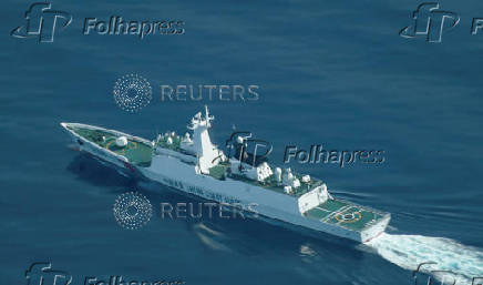 An aerial view of a China Coast Guard ship navigating near the disputed Scarborough Shoal, as Philippine Coast Guard aircraft carrying journalists patrols the area
