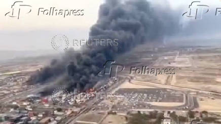An aerial view shows plumes of thick black smoke rising, following a suspected explosion of chemical materials