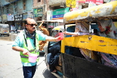 Volunteers distribute cold drinks on a roadside in Hyderabad