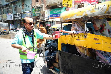 Volunteers distribute cold drinks on a roadside in Hyderabad