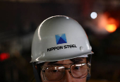 A worker wears a helmet with The Nippon Steel logo, inside the plate rolling mill area at the company's East Nippon Works Kimitsu Area plant in Kimitsu