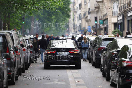 French taxi drivers gather for a strike protesting over proposed government cuts to cash for ferrying patients to and from medical appointments, in Paris