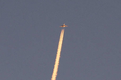 A military aircraft flies in the sky following a barrage of missiles launched from Iran, as seen over Tubas