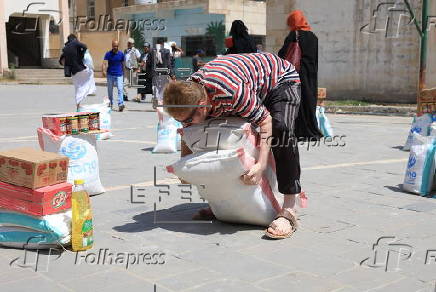 Yemenis receive food aid in Sana'a, distributed by Mona Relief agency