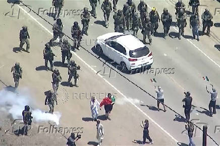 Federal agents force protesters to move back during an immigration raid on an agricultural facility in Camarillo