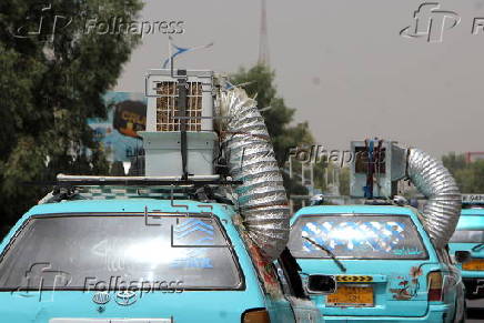 Taxi drivers install locally made air coolers to beat the heat in Kandahar